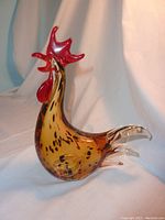 Side view showing the full amber-yellow body with dark spots and clear glass tail feathers.