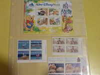 Photo showing Walt Disney World themed Canadian stamp sheet with Winnie the Pooh, Tigger, and castle, along with other stamp blocks and sheets