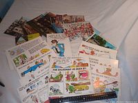 Photo showing a variety of humorous postcards with cartoons and text messages laid out with a ruler for scale.