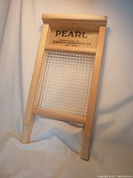 Small handheld washboard upright on white fabric background