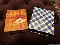 Two toiletries kits with distinct packaging: Philosophy The Gingerbread Girl in a brown gingerbread-themed box and Bath & Body Works Gingham in a blue gingham box.