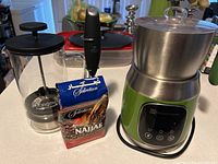 Photo of the Dorothy rapid cold brewer, Zulay Kitchen milk frother resting on a bag of Selection Najjar coffee, and Maestri House milk steamer unit.