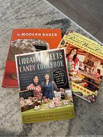 Photo showing all three cookbooks stacked, titles visible