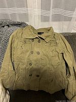 Front view of the army green cotton Hurley jacket showing button and zipper closure, chest pockets, and collar.