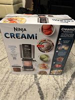 Photo of boxed Ninja Creami showing front with product images and branding.