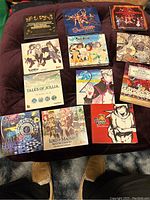 Top view of 11 soundtrack CDs arranged on a surface showing colorful anime and video game themes including Tales of Xillia, Conception, Senran Kagura, Lord of Magna, and others.