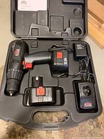 Jobmate cordless drill in its black hard plastic carrying case with two 12V batteries and charger