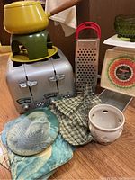 Full lot showing toaster, retro fondue pot, grater, coasters, and part of the scale