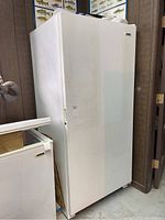 Front and side view of white upright freezer with closed door