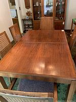 Solid wood dining table rectangular top with wood grain and six chairs around it