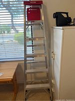 Full view of Werner aluminum step ladder set up inside room showing length and step design.