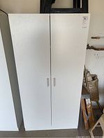 White tall garage storage cabinet with two doors, front view showing clean exterior and simple handles.