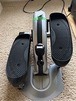 Top view showing two large black textured pedals with tread pattern and a central silver body containing the digital display unit.