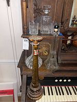 Photo of glass and crystal decanters along with two vintage decorative bottles on wooden surface; details of shape, color, and stopper visible.