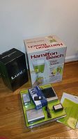 Three boxed items: Hamilton Beach Wave Station blender, Lunix cordless hand massager and a blister pack containing Casio portable TV and accessories.