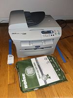 Front view of Brother DCP7020 printer with Boise multipurpose paper pack in front.