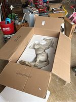 Resin horse sculpture packed in an open cardboard box with foam inserts for protection.