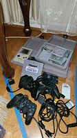 Overview showing Game Boy console in case, Super Game Boy adapter, cartridge carriers, controllers and cables