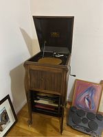 Full view of open wood cabinet phonograph with records below