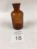 Side angle view of the brown Lysol bottle highlighting its shape and amber color.