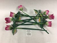 Seven hand carved and painted wooden roses arranged on a white background showing the overall set and colors.