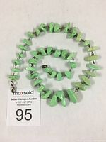 Coiled view of the light green beaded necklace with visible sterling silver chain and clasp.