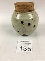 Front view of garlic pot with cork stopper and visible side holes for ventilation.