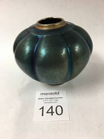 Front angled view showing vase shape and reflective iridescent glaze.