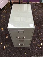 Top view of the file cabinet showing the plate glass cover, reflecting surroundings, on outdoor ground.