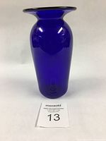 Front view of the deep cobalt blue hand blown glass vase showing smooth surface and wide flared rim.