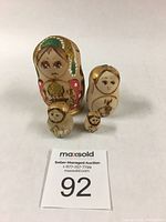 Five Russian Matryoshka nesting dolls varying sizes arranged with auction lot number 92 in front.