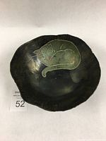 Overhead photo of the raku pottery bowl showing entire sleeping cat design and overall bowl shape.