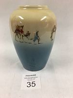 Full view of vase with gradual blue-to-cream glaze and hand painted Sahari camel scene.
