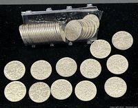 Plastic tube holding a full roll of five-cent coins with loose examples displayed