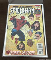 Front cover of The Amazing Spider-Man #1 Specular Issue News Stand Variant comic by Marvel, showing Spider-Man and character faces with yellow web background, bagged and boarded.