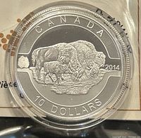 Close-up of the coin face showing engraving of bison family with inscriptions and year 2014.