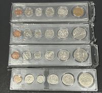 Four sealed uncirculated Canada coin sets stacked, each containing six coins in plastic packaging.