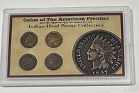 Four Indian Head pennies sealed in plastic casing with a labeled card