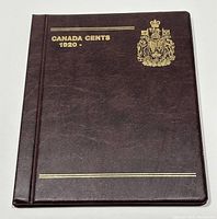 Front cover of the coin album with brown faux leather binding, gold embossed text and crest.