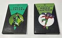 Two hardcover Green Lantern Archives comic books from DC Archive Editions series with distinct cover art showing the Green Lantern characters on a green and black background.
