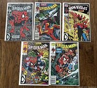 Five comic books laid out on wood floor, showing full front covers of Spider-Man #1 to #5 of the Torment series, each bagged and boarded.