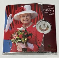 Photo of commemorative display packaging showing Queen Elizabeth II and the coin in a clear bubble on a red background