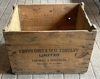 Front view of large wooden crate showing branding and age wear on wood surface