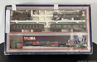 Top down view of the train set in original box showing locomotive, passenger cars, freight car, and packaging