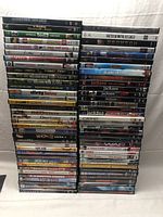 Two tall stacks of DVD movies in their cases showing a variety of titles and genres.
