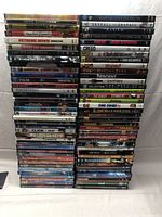 Photo showing multiple stacks of DVD movie cases with clear titles and artwork visible.