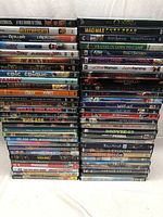 Photo showing stacks of various DVD movies including titles like Mad Max Fury Road, Percy Jackson, Kick-Ass, and others.