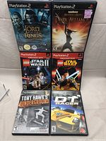 Front view of all six PlayStation 2 game cases arranged in two rows showing cover art and titles.