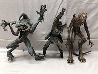 Three movie figures standing side by side on a flat surface