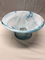 Front angle view of large frosted glass pedestal bowl showing turquoise swirl design and pedestal base.